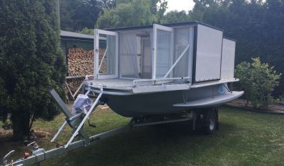 Loď se závěsným motorem a vozíkem.